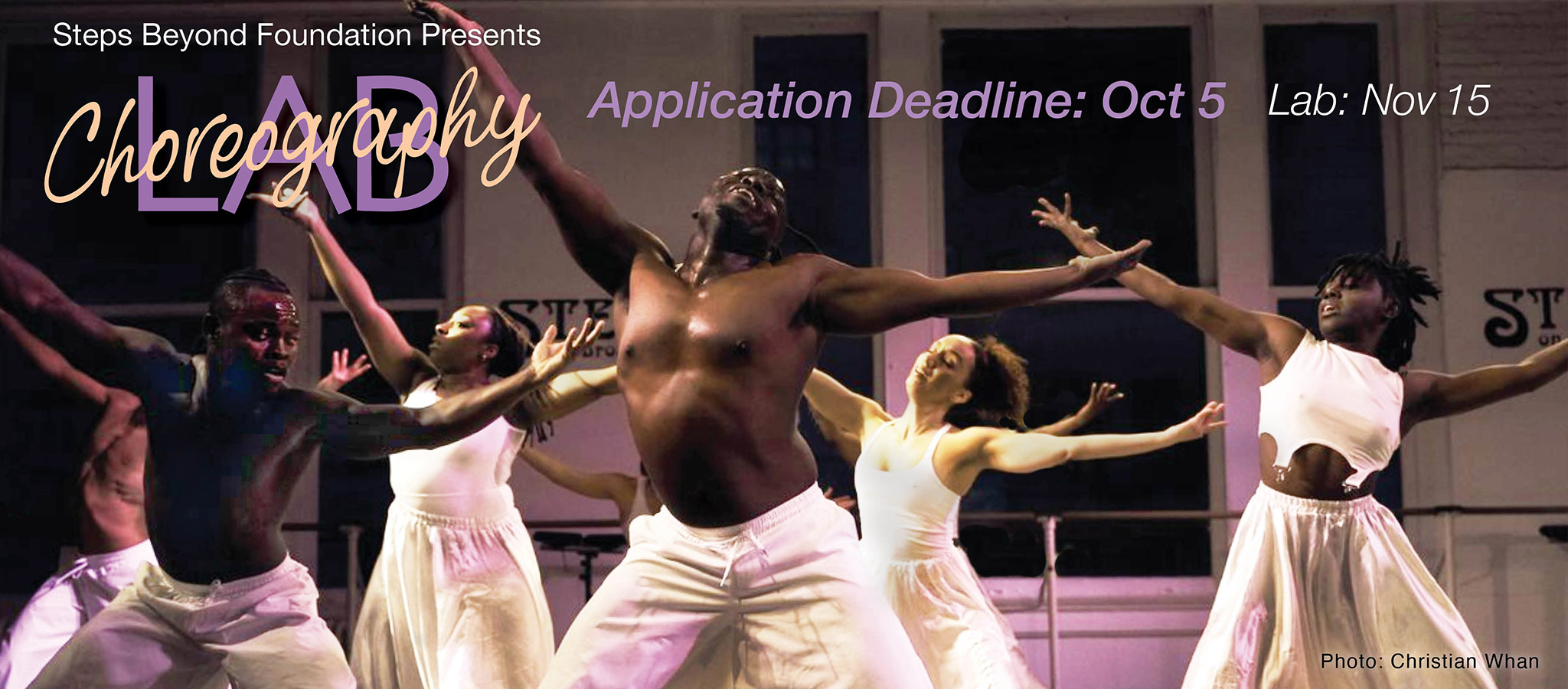 A group of dancers all in white facing the audience with arms and legs spread joyously wide